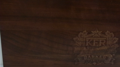 Close-up of custom laser engraving on a walnut cutting board